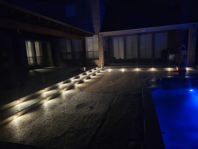 outdoor pool patio with stairs and lighting